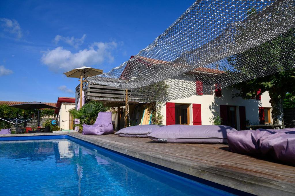 AzurThe Secret Spot Lodge的一座带紫色枕头的游泳池位于房子旁边