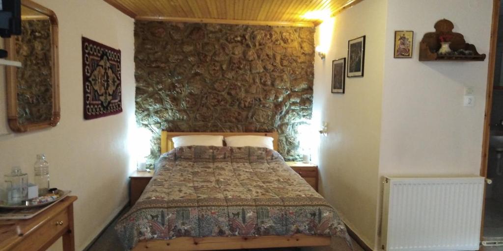阿拉霍瓦Country Style Room at the Center of Arachova的一间卧室设有一张床和石墙