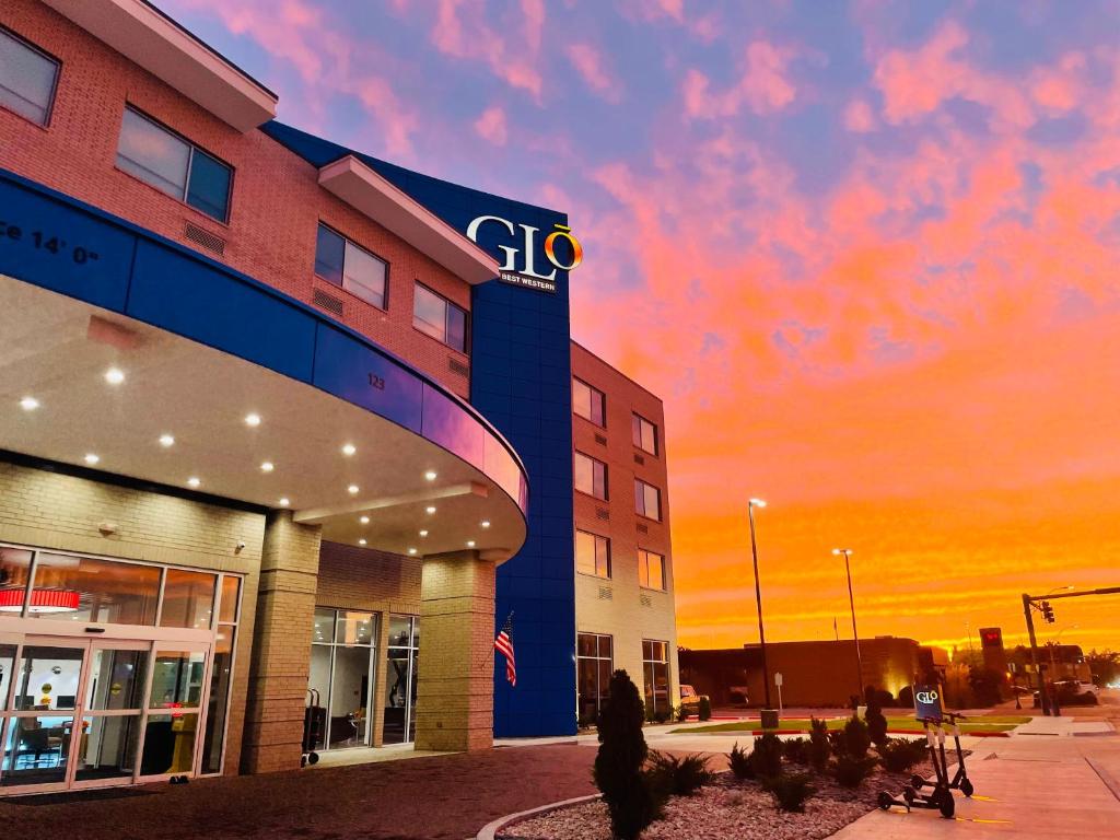 EnidGLō Best Western Enid OK Downtown - Convention Center Hotel的站在建筑物前走的女人