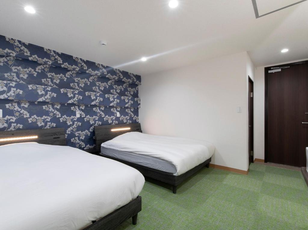 Tabist Hotel Miyakonojo Miyazaki客房内的一张或多张床位