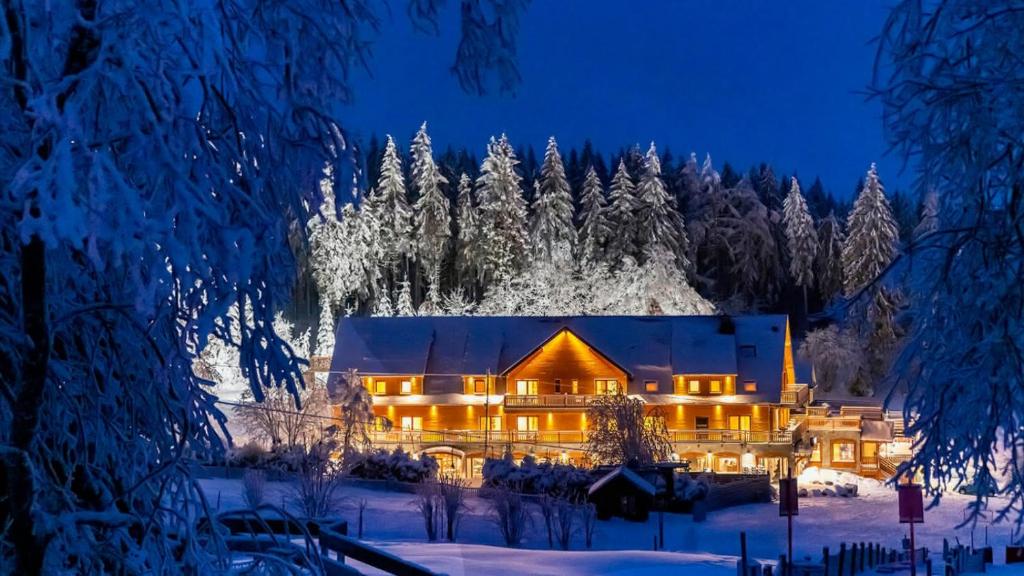 贝尔蒙特Hotel Restaurant Mont Champ du Feu的夜晚雪中的房子