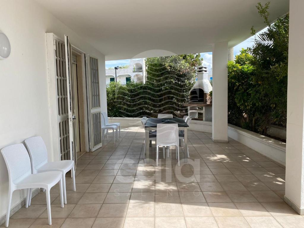 托雷拉皮罗Villa Goa Beach的房屋内设有带白色椅子和桌子的庭院