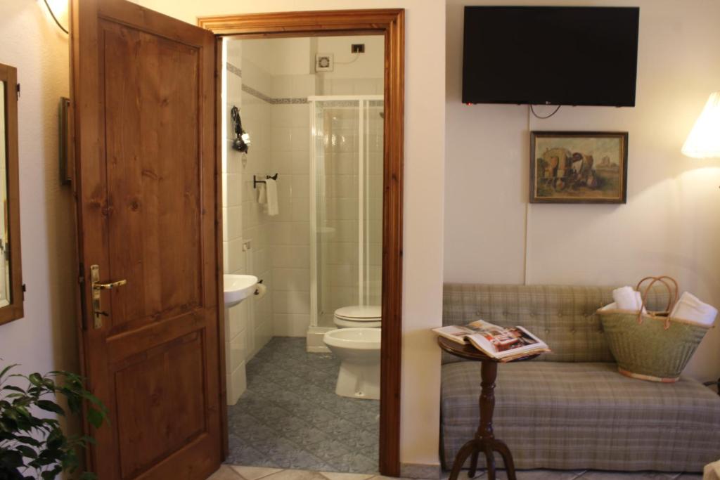 新吉蒂诺瓦达恩Boutique Hotel Fox's Inn的一间带卫生间的浴室和墙上的电视