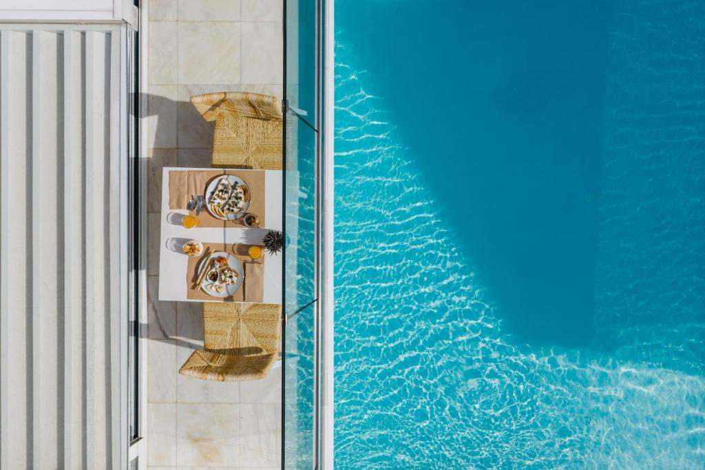 普拉基亚斯Cyano Hotel的享有带桌椅的游泳池的顶部景致