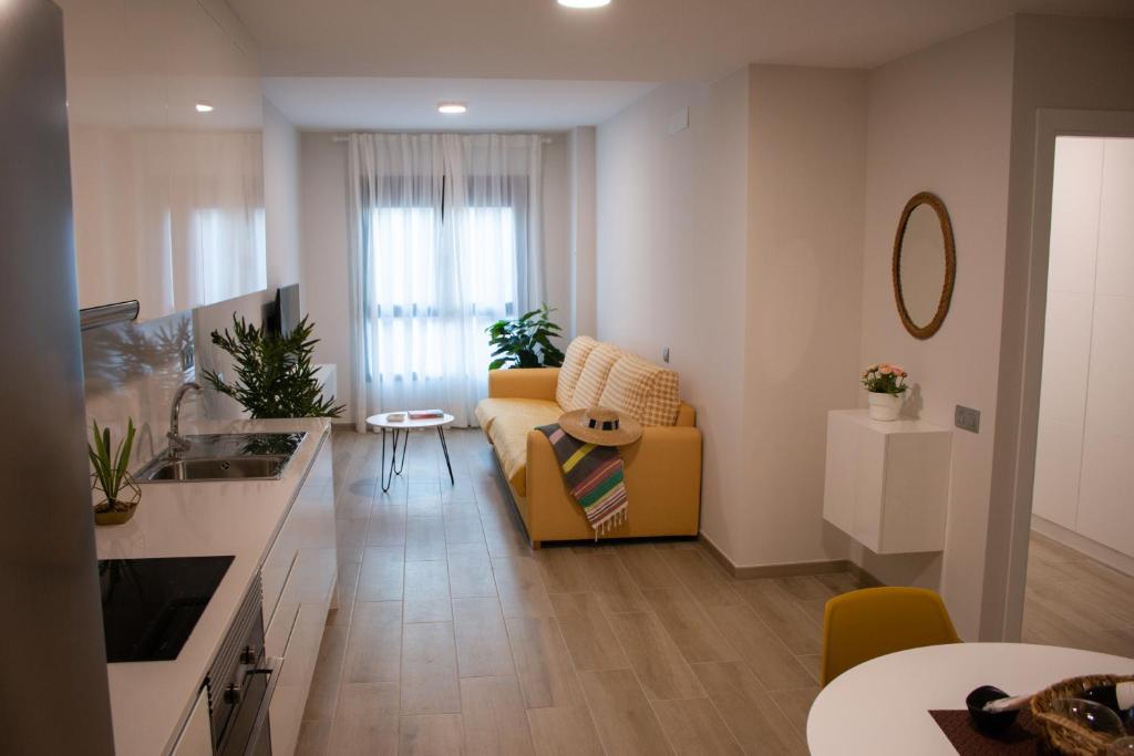 大加那利岛拉斯帕尔马斯Gloriamar Las Canteras的一间带黄色沙发的客厅和一间厨房