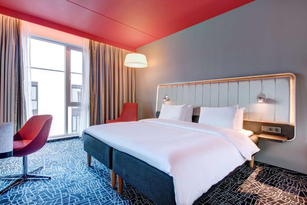 奥斯陆奥斯陆奥纳丽笙酒店的酒店客房带大床和红色椅子