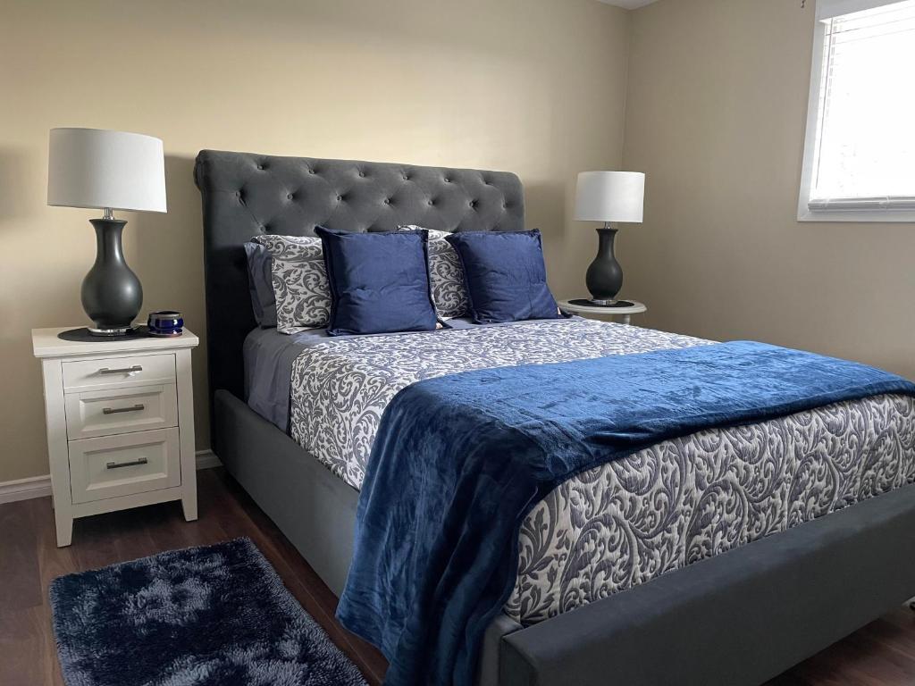 滑铁卢Hammer Haus III的一间卧室配有一张带蓝色毯子和两盏灯的床。