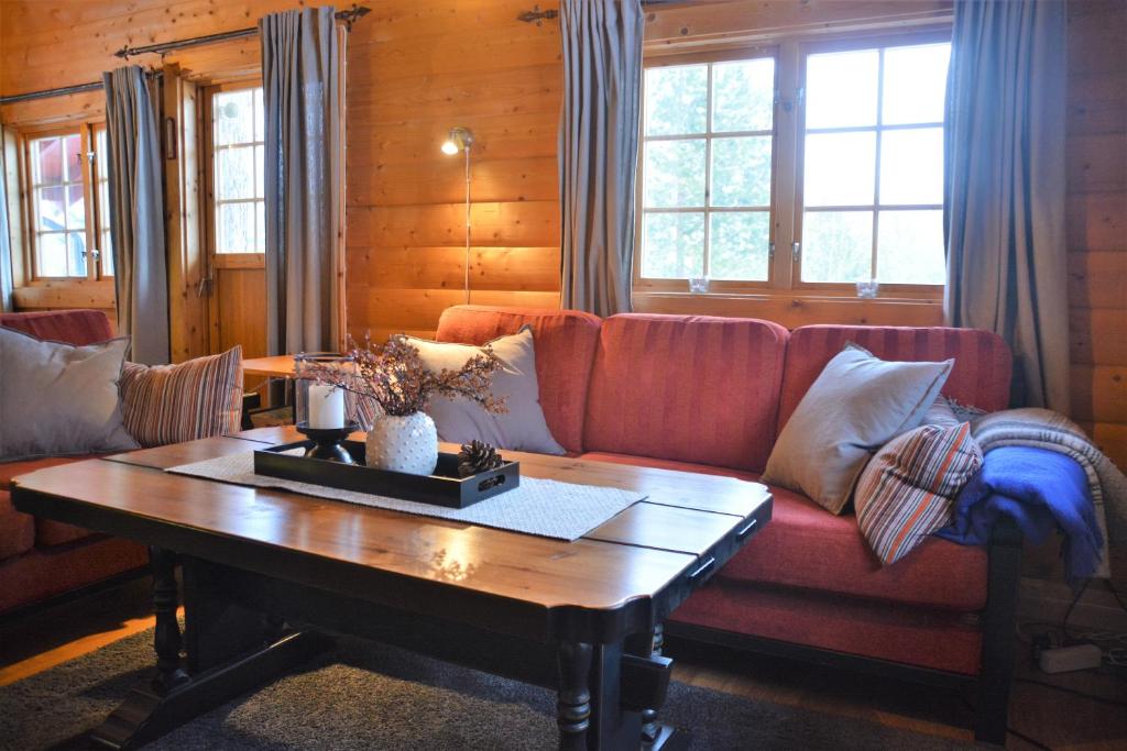 SønstebøUvdalhytta - close to cross country and downhill skiing的客厅配有红色沙发和茶几