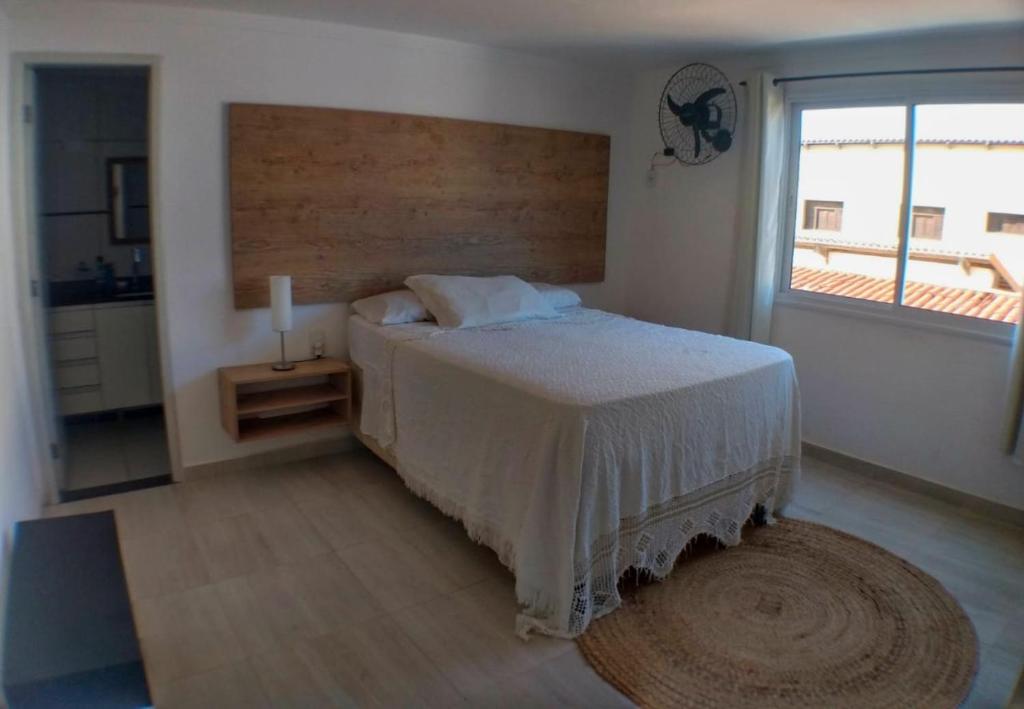 尼西亚弗洛雷斯塔Apartamento Duplex beira Mar的一间卧室设有一张床和一个大窗户