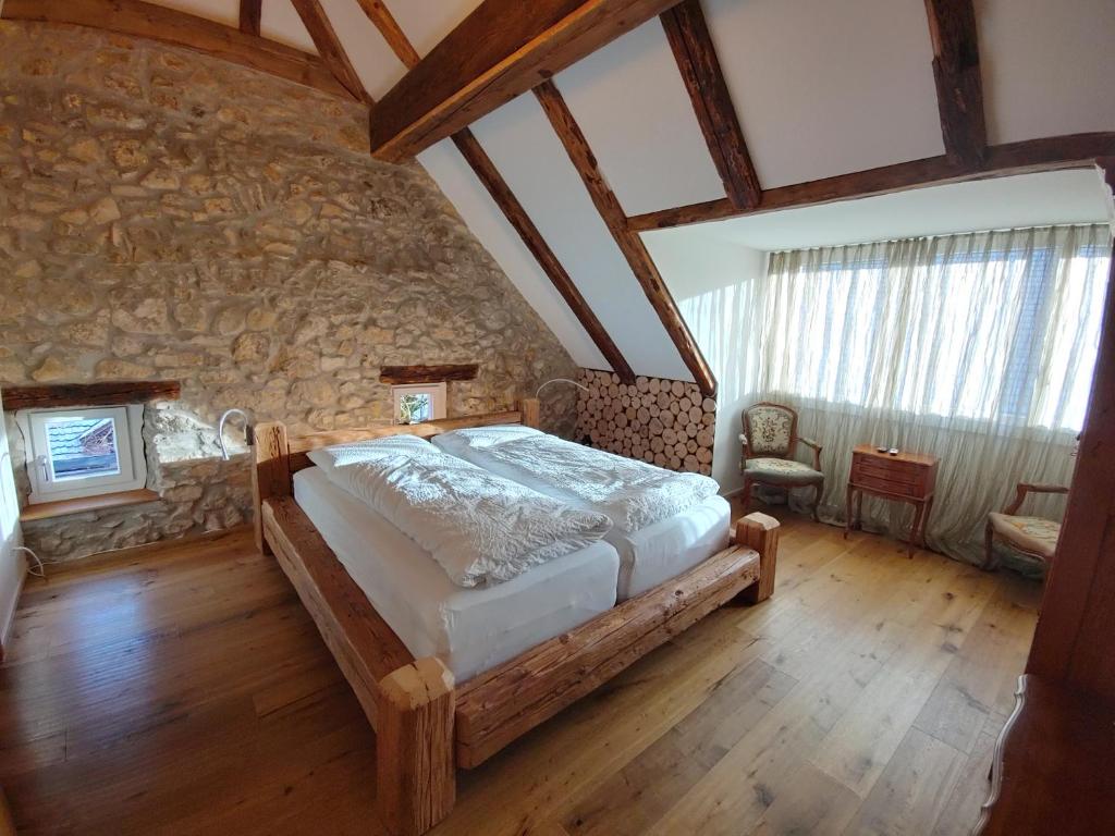 NunningenLandgasthof Roderis的一间卧室设有一张床和石墙