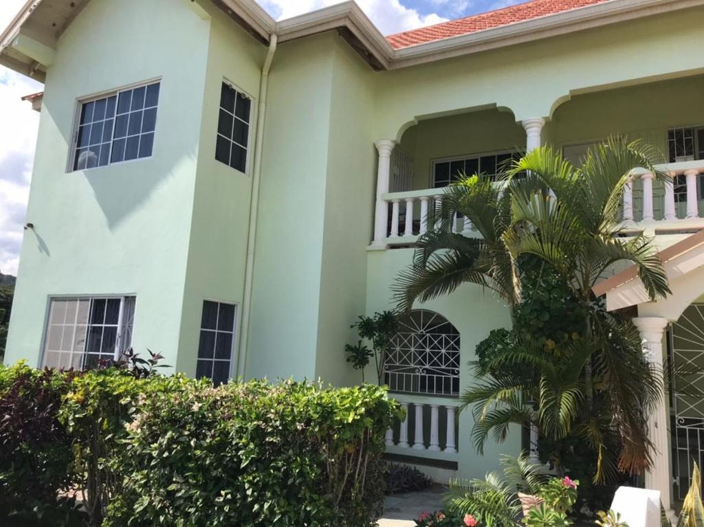 银沙Beautiful 2-Bed Apartment in sunny Jamaica的前面有棕榈树的白色房子