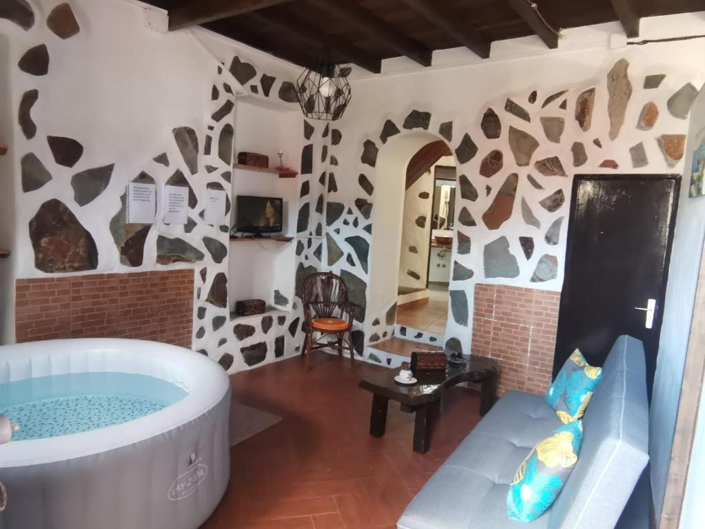 洛斯雷亚莱霍斯Casita Rural con Jacuzzi climatizado.的一间客厅,位于房间中间,配有浴缸