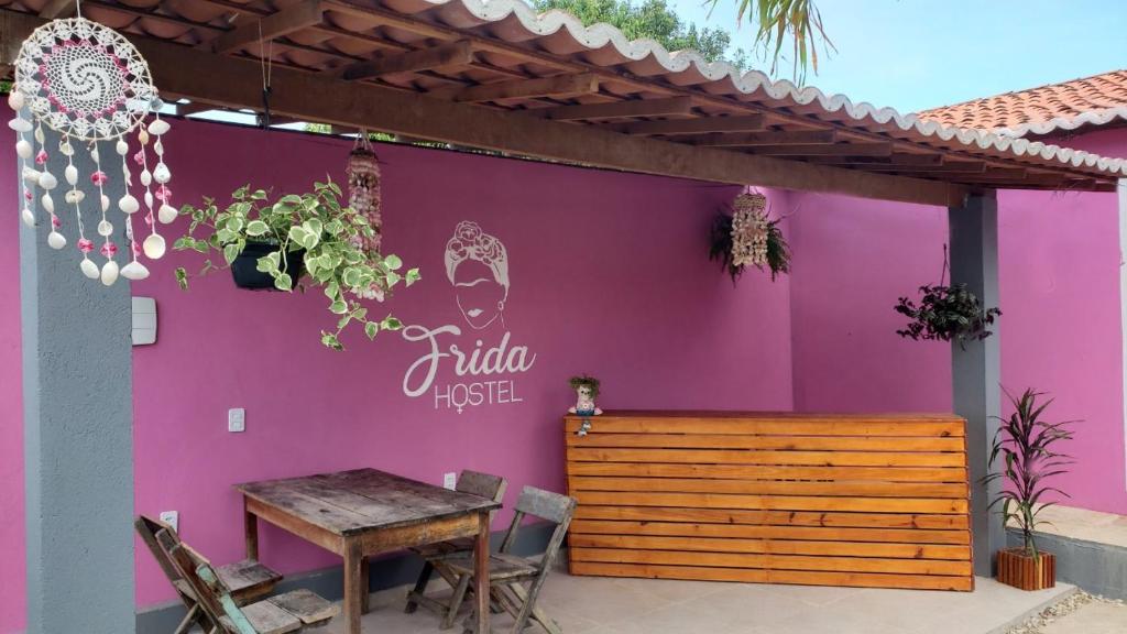 杰里科科拉Frida Hostel的紫色的墙,前面有桌子