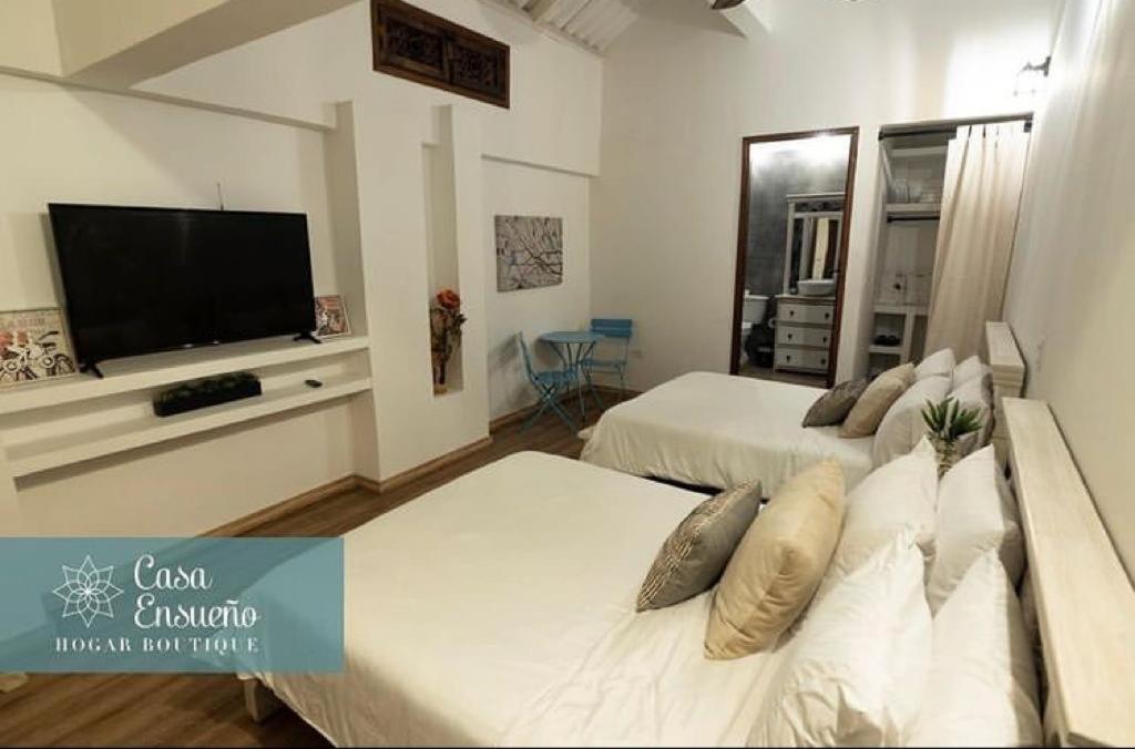 瓜杜阿斯Casa Ensueño Hogar Boutique的客厅配有两张床和一台平面电视