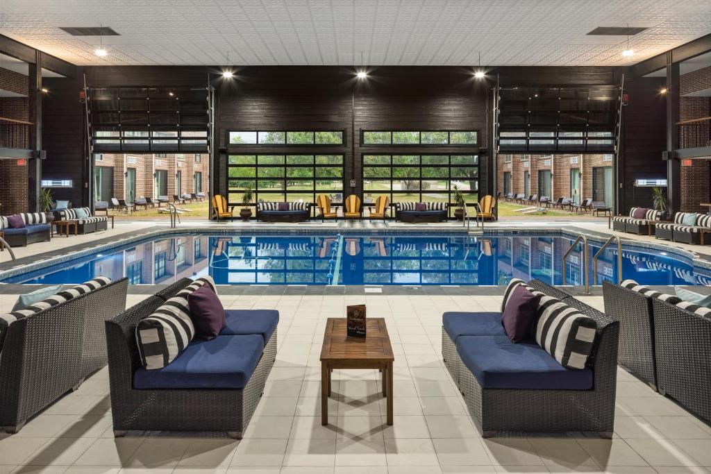 爱荷华The Highlander Hotel的前面设有1个带椅子和桌子的大型游泳池