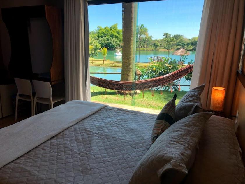 巴西利亚Villa Triacca Hotel Vinícola & Spa的一间卧室配有一张床,窗户配有吊床