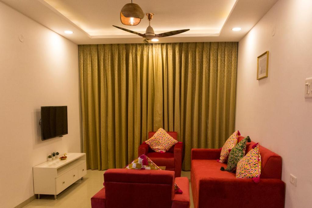 阿伯来ComfyCorner - Luxurious 2-BHK Apartment的客厅配有2把红色椅子和绿帘