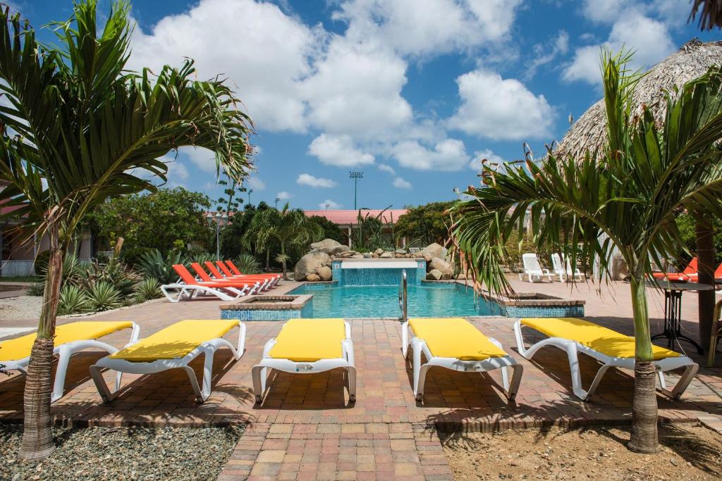 奥拉涅斯塔德卡马库里公寓酒店的一个带黄色躺椅的游泳池和一个游泳池