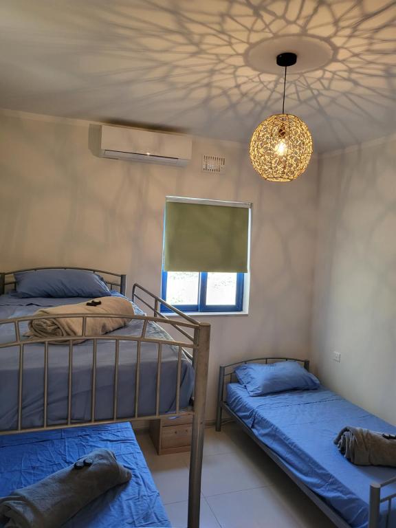 艾因西莱姆Ir-Rixa Holiday Penthouse的一间卧室设有两张双层床和吊灯。
