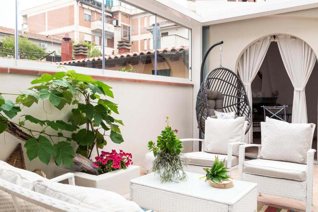 福洛尼卡Acquamarina b&b的阳台配有白色椅子和盆栽植物