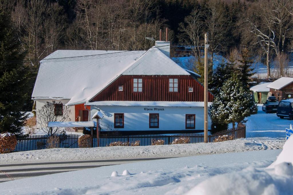 小莫拉夫卡Chata Myšák的一座红白色房子,有雪盖屋顶