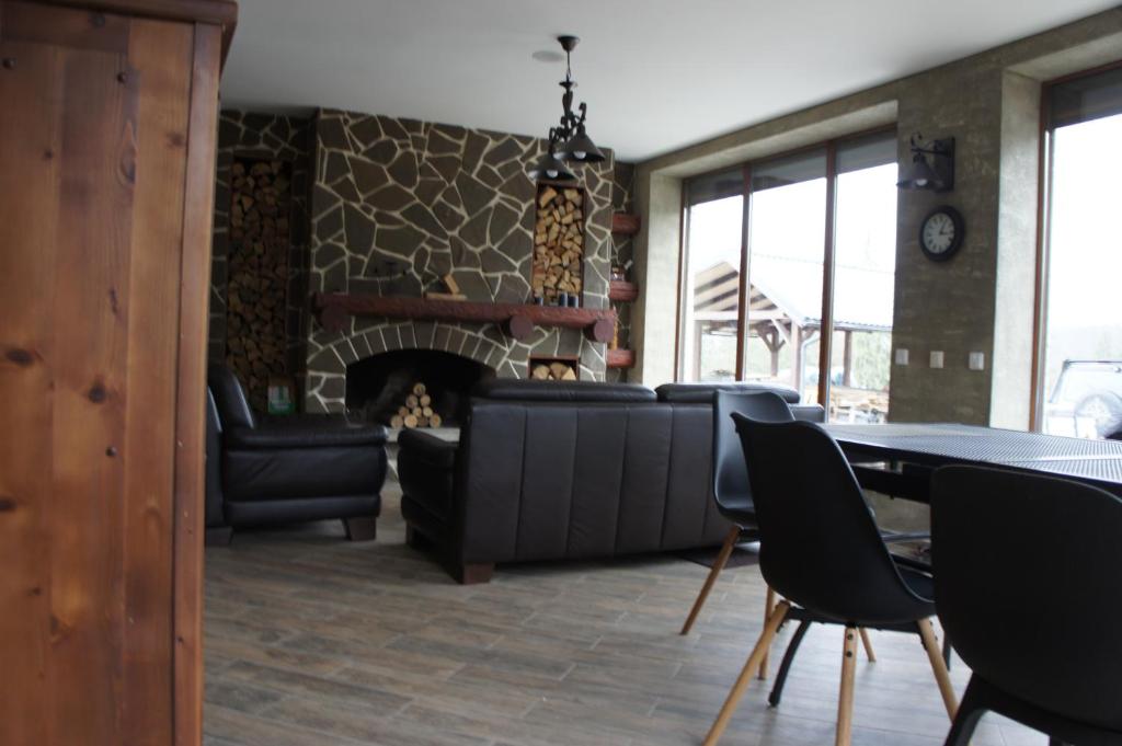 KrivopolʼyeUnderДіл的客厅设有壁炉、桌子和椅子