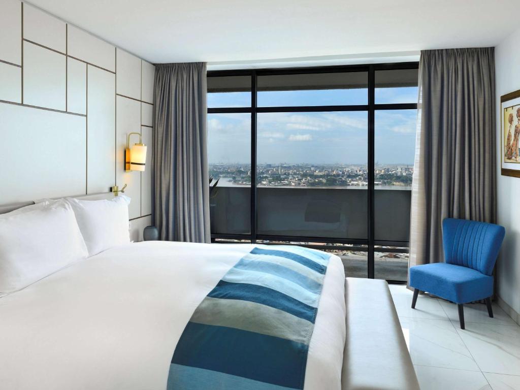 阿比让阿比让科特迪瓦索菲特酒店的酒店客房,配有一张床和一张蓝色椅子