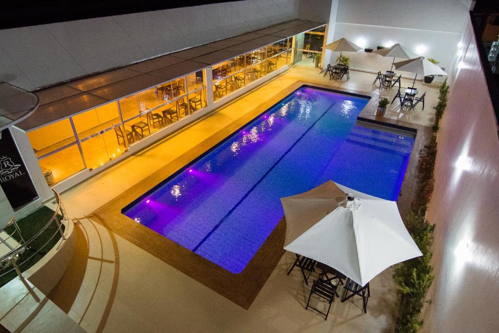 马卡帕ROYAL Hotel & Gastronomia的游泳池顶部景,带遮阳伞