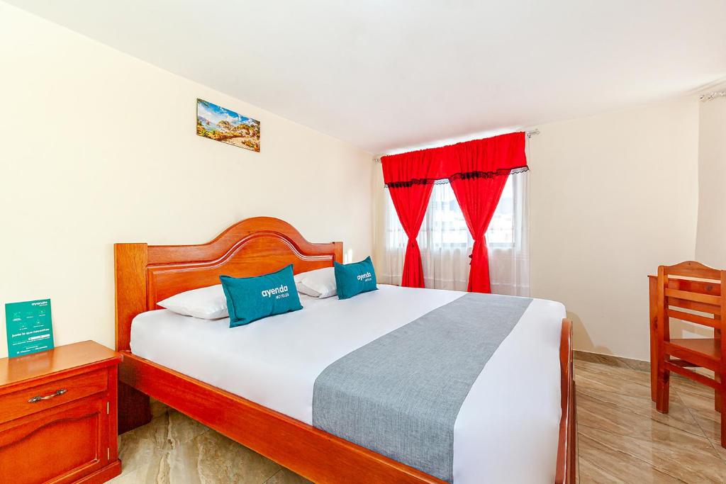 帕斯托Ayenda Onix Suite的一间卧室配有床和红色窗帘的窗户