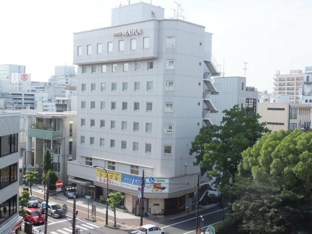 冈山玛丽亚酒店的城市街道上高大的白色建筑,有汽车