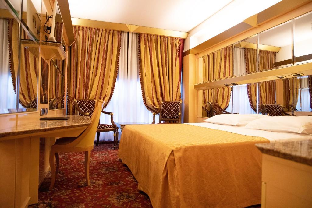 米兰Hotel Wagner的配有一张床和一张书桌的酒店客房