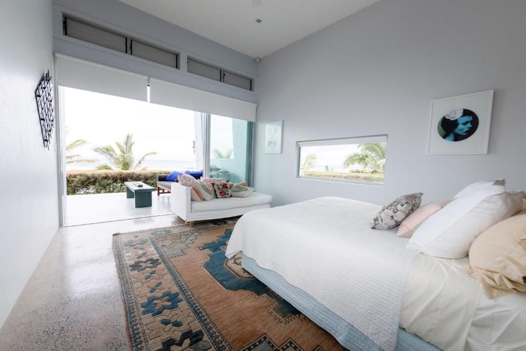 拉罗汤加Coast Cook Islands的白色的卧室设有床和大窗户