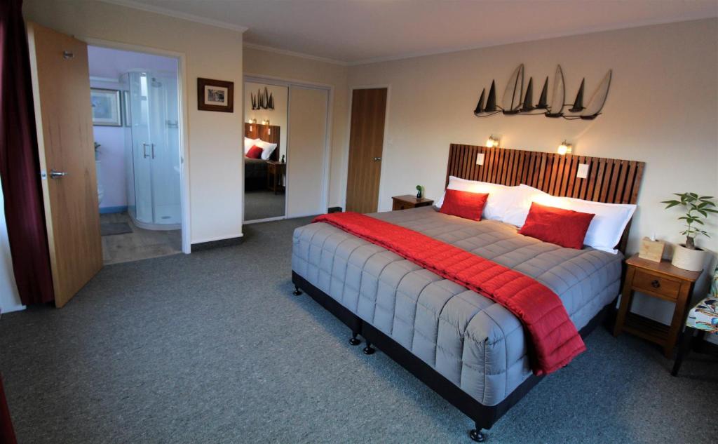 塔卡卡Labyrinth Gardens Guest House的一间卧室配有一张带红色枕头的大床
