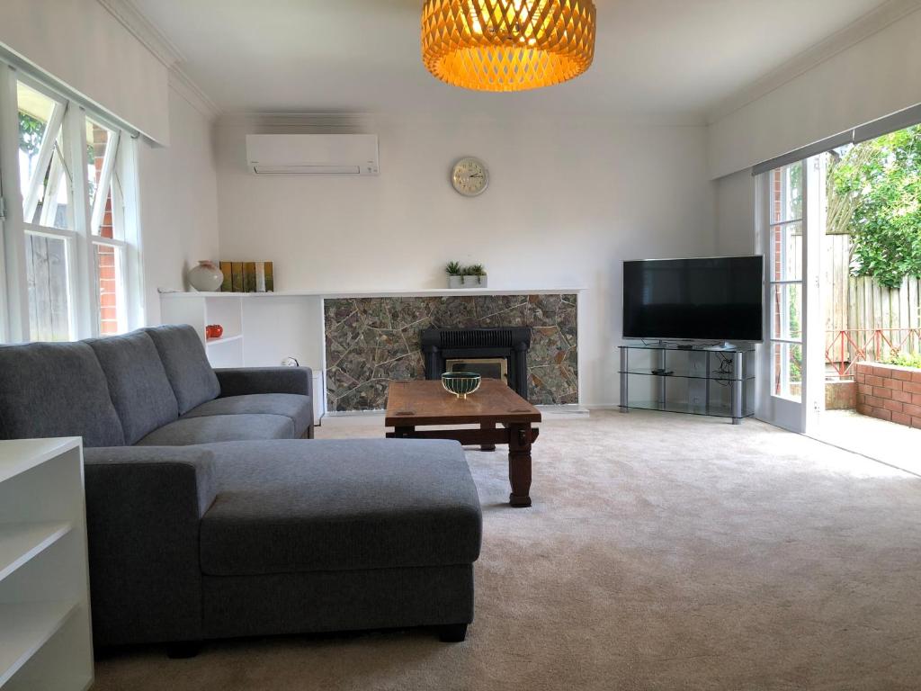 奥克兰Comfortable Holiday Home at Mt Wellington的带沙发和壁炉的客厅