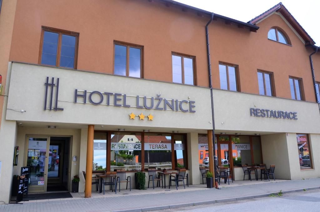 Planá nad Lužnicí卢日尼采酒店的一座酒店村,楼前设有桌椅