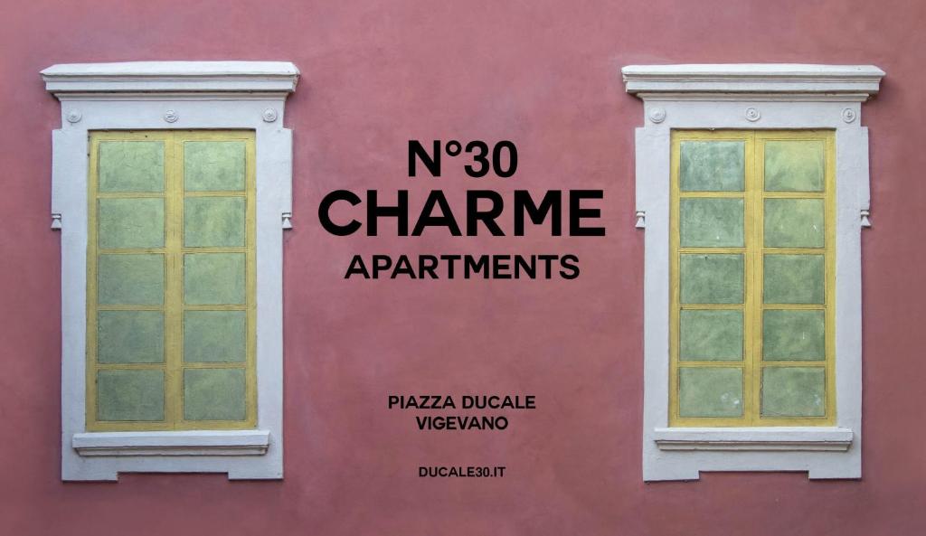 维杰瓦诺N°30 CHARME Apartments的粉红色的墙壁,上面有两扇窗户