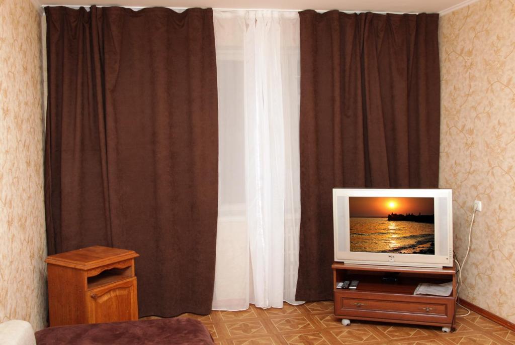 第聂伯罗Pobeda Apartment的一间客厅,配有一张桌子上放的电视
