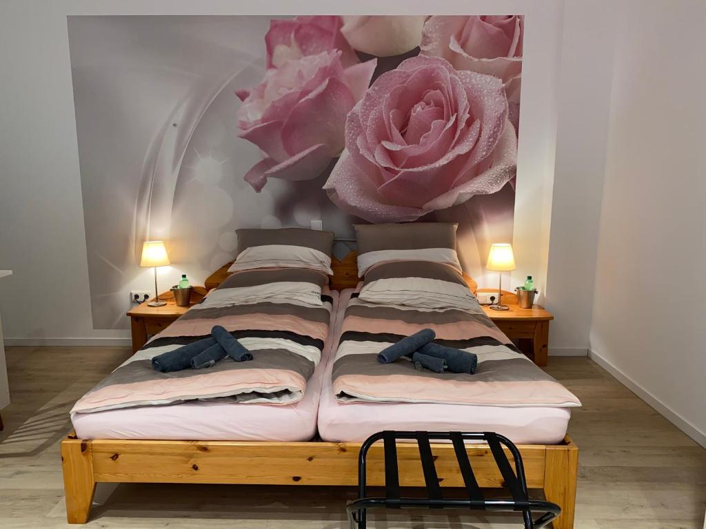 杜塞尔多夫Home-Rose-Garden-Gästehaus kontaktloser Zugang的卧室配有四张床,墙上挂着粉红色的鲜花