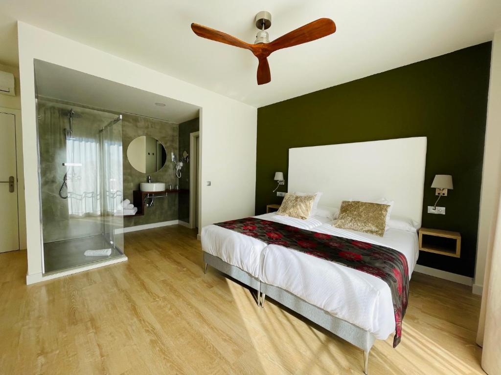林孔-德拉维多利亚Añoreta Suites的一间卧室配有一张床和吊扇