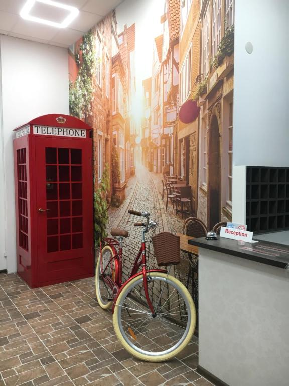 利沃夫Hotel Rover的红色电话亭和停在街上的自行车