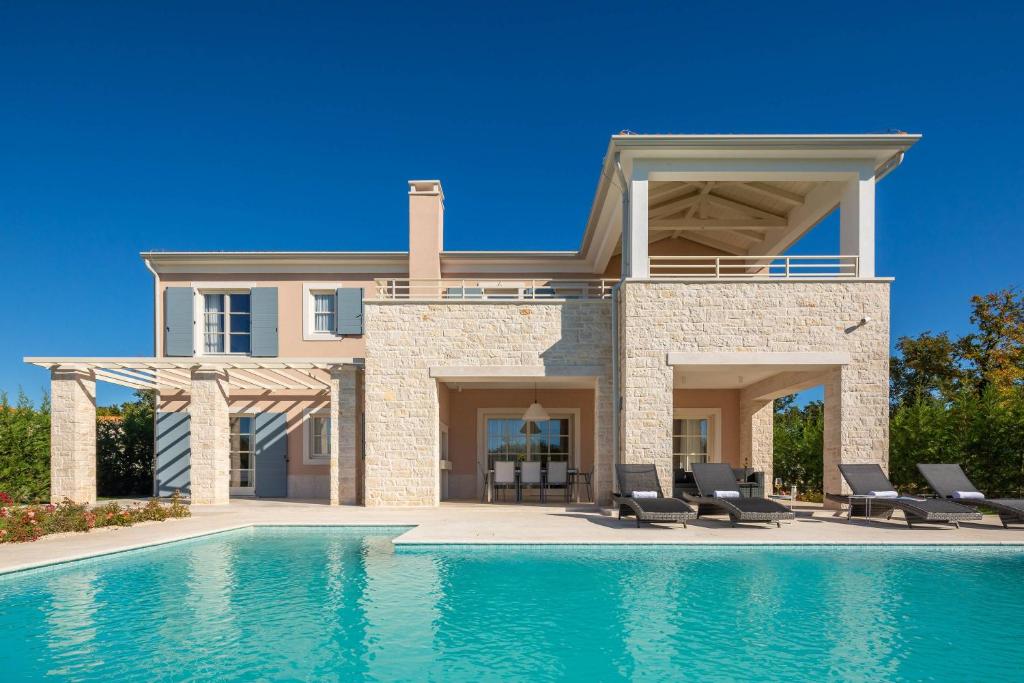 布罗托尼贾Villa Divine by ILC (Istria Luxury Collection)的房屋前有游泳池的房子