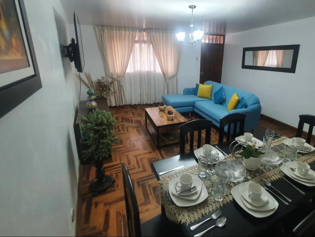 卡哈马卡Depa Céntrico, cerca a todo!的客厅配有桌子和蓝色沙发