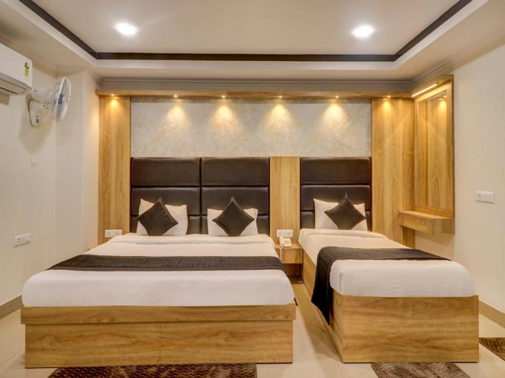 新德里HOTEL DAKHA INTERNATIONAL - Karol Bagh, New Delhi的卧室内的两张床,墙上有灯