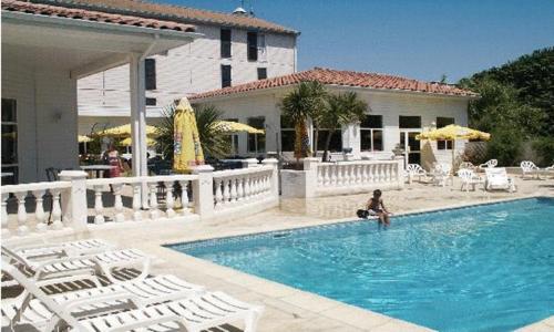 拉特斯Hotel & Restaurant Le Mejean - Parc des Expositions的坐在游泳池的女人