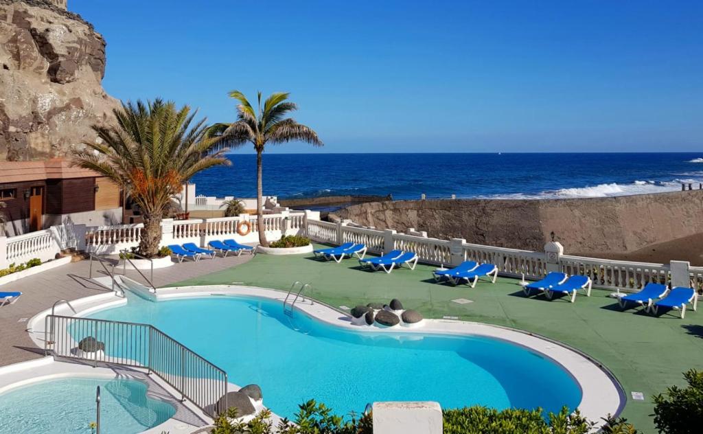 La EstrellaMaravillosa vivienda con piscina al lado del mar的一个带椅子的游泳池,背景是大海