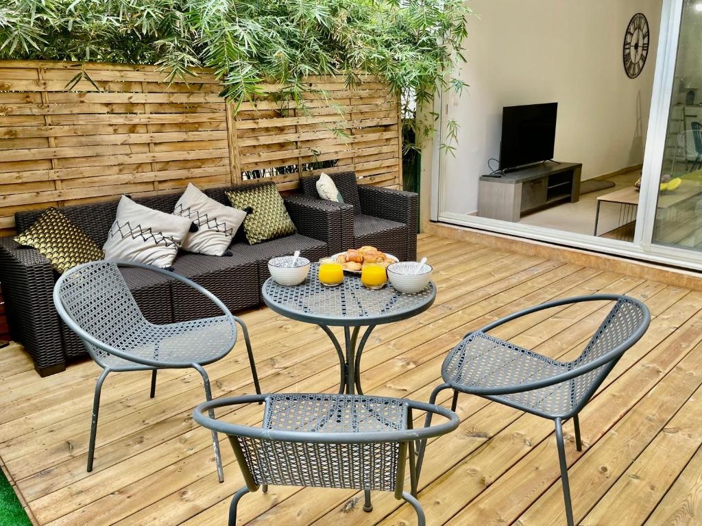 圣丹尼斯Nouveauté - L'Oasis - T3 - 70 M2 - Jacuzzi的庭院配有两把椅子、一张桌子和一张沙发