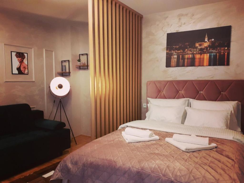 帕莱Apartman Planinski Kutak的一间卧室配有一张床,上面有两条毛巾