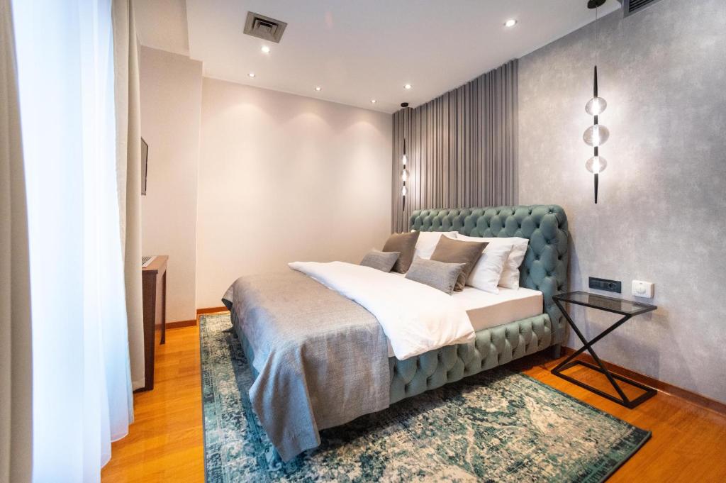 贝尔格莱德NATALI Luxury suites的一间卧室配有一张带绿色床头板的床