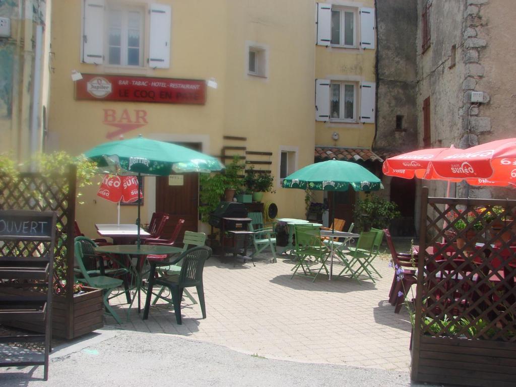 La Roque-Esclapon科克恩佩特酒店的一个带桌椅和遮阳伞的户外庭院。