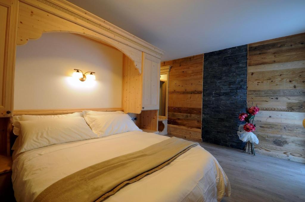 Croviana梅丽莎农家乐的一间卧室设有一张大床和一堵木墙